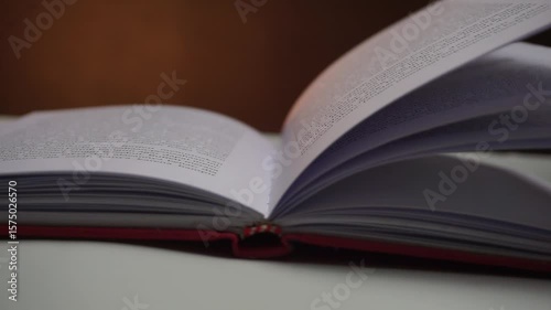 Open book with pages fluttering in the wind, warm backlight and black background create a cinematic scene, ideal for literary, poetic, or nature-inspired themes