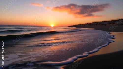 Coastal sunset video featuring warm tones sea waves meeting the shore reflection of the sunset on the water. Orange sky background peaceful serene scene