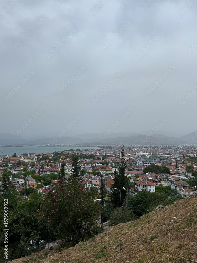 Fototapeta premium View of a coastal town from a hilltop on a cloudy day