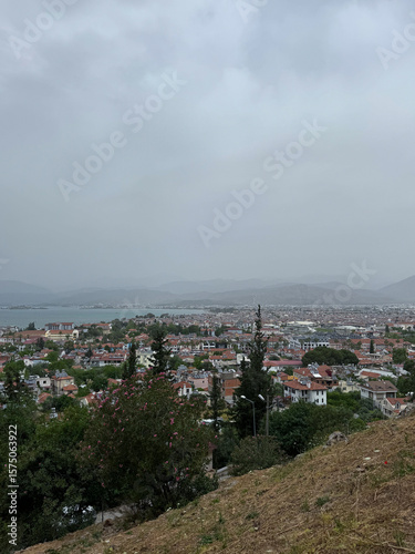 Fototapet View of a coastal town from a hilltop on a cloudy day