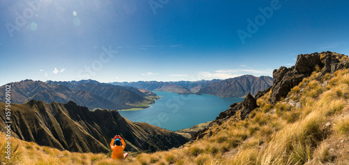 Fototapeta Naklejka Na Ścianę i Meble -  Rear view of hiker enjoying the  views of lake Hawea from the Isthmus track walkway