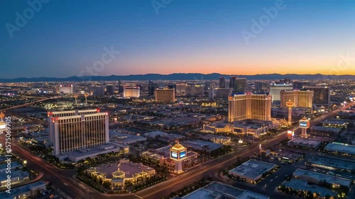 Aerial View of Las Vegas Cityscape at Dusk with Illuminated Buildings and Roads under Twilight Sky