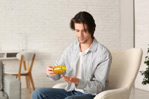 Young man taking daily vita...