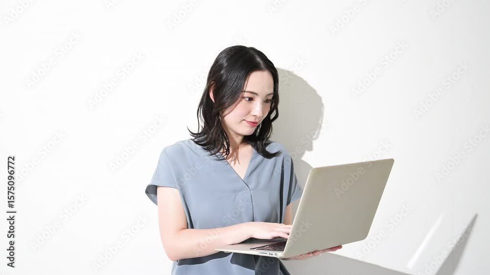 白背景(白バック)でパソコンを持つ爽やかな春夏の半袖ビジネス(オフィスカジュアル)の女性 転職や人事などのリクルートのイメージ 動画 白背景(白バック)でパソコンを持つ爽やかな春夏の半袖ビジネス(オフィスカジュアル)の女性 転職や人事などのリクルートのイメージ 動画