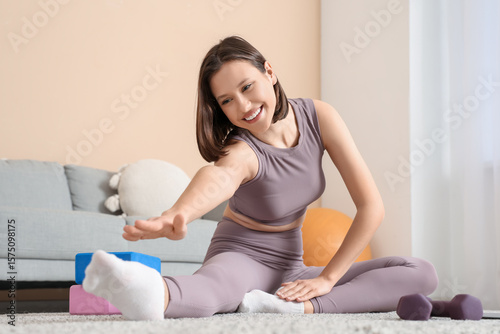 Sporty young woman stretchi...