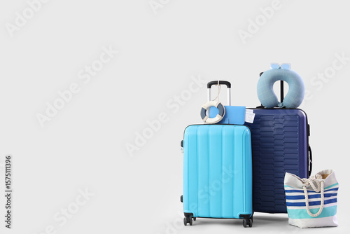 Suitcases and beach accessories on white background