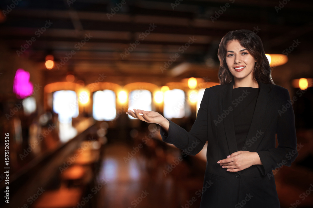 Fototapeta premium Young hostess in uniform welcoming to restaurant