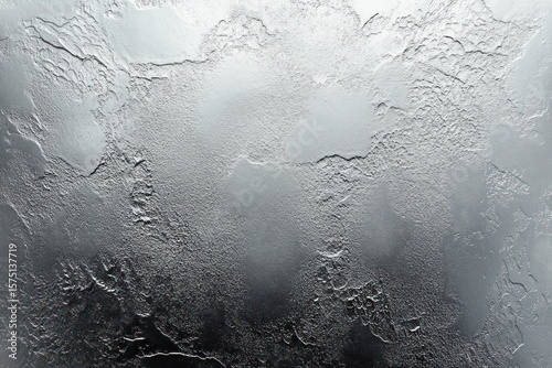 Close-up of textured surface with a gradient transition from light gray at the top to dark gray and black at the bottom, featuring rough, cracked, and uneven patterns