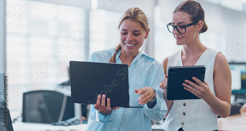 Women Engaging in Collaborative Efforts on Digital Devices within a Contemporary Office Environment