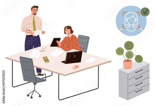 Two professionals discussing project at office desk with laptop, documents, and tablet. Facial recognition icon and potted plant on cabinet. Ideal for teamwork, workplace, technology, security