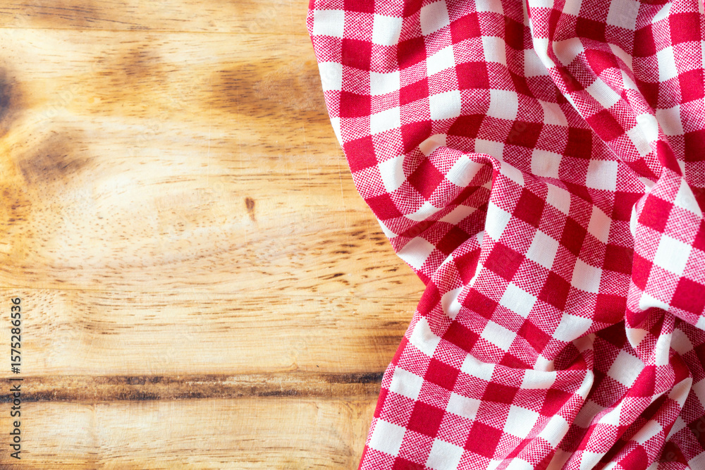 Obraz premium Red and White Checkered Tablecloth on Rustic Wooden Background