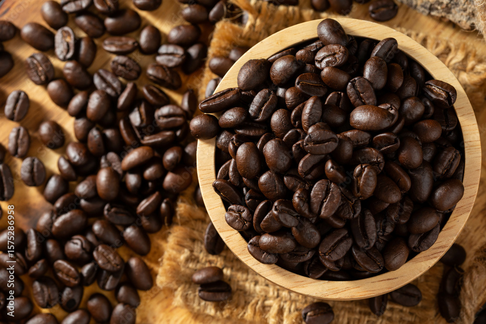 Fototapeta premium Roasted Coffee Beans in a Wooden Bowl with Spilled Grains