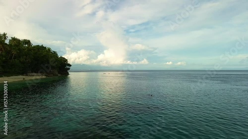 Wallpaper Mural Gentle aerial flight to the end of Beach Ni Kapitan, revealing lush cliffs, serene turquoise waters, and expansive sea views near Pangubatan, Samal Island. Torontodigital.ca