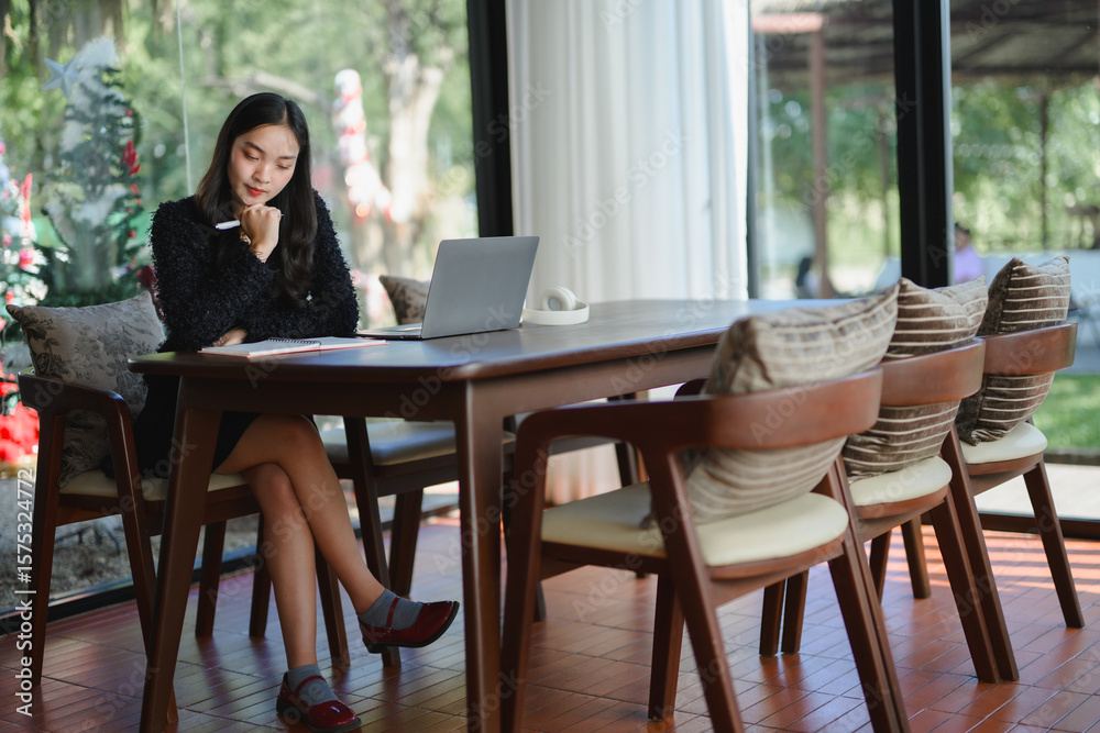 Businesswoman working on laptop and taking notes in modern office meeting room Businesswoman working on laptop and taking notes in modern office meeting room