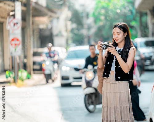 Young tourist taking photos in a street of Bangkok