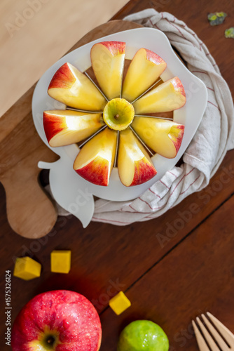 Canvas Print A close-up of a fresh red apple fruit on a round apple slicer.