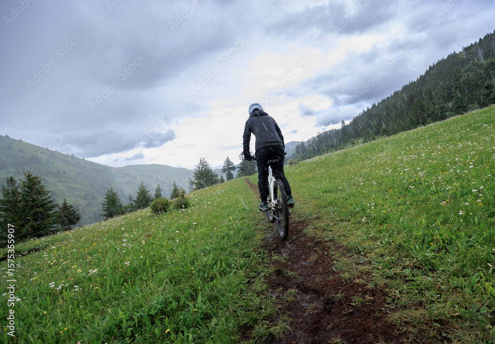 Fototapeta premium Riding mountain bike on grassland forest mountains