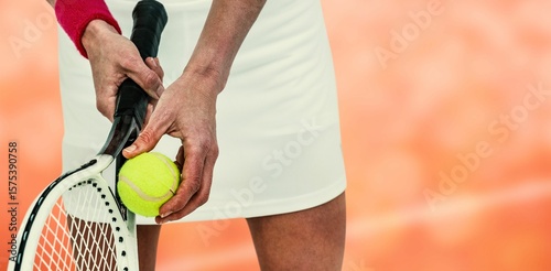 Midsection of sportswoman holding tennis racket