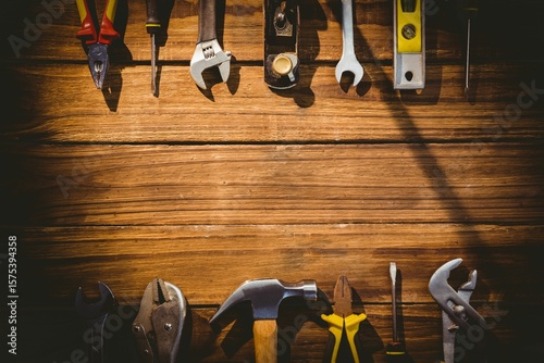 Flat design is showcasing pliers, screwdriver, wrench, hammer on wooden surface, copy space