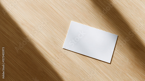 A blank notecard placed on a wooden desk with soft diffused lighting and shallow focus.