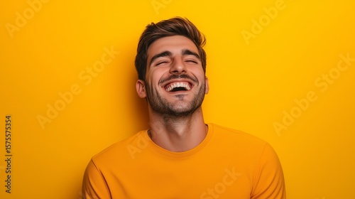 A man laughing with joy on a bright yellow background, authentic expression, slightly tilted head, captured mid-moment
