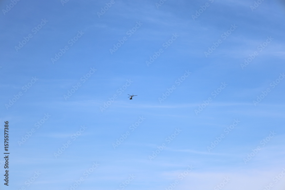 Fototapeta premium helicopter on distance on blue sky