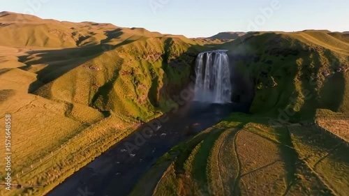 Idyllic Waterfall Flowing Gracefully Through Serene Green Hills Landscape