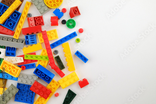 Scattered colorful plastic building blocks on a white background.