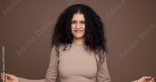 Hair care, confused and face of woman in studio with beauty, messy or damage for treatment. Upset, portrait and female person from Mexico with frizz for curly hairstyle fail by brown background.
