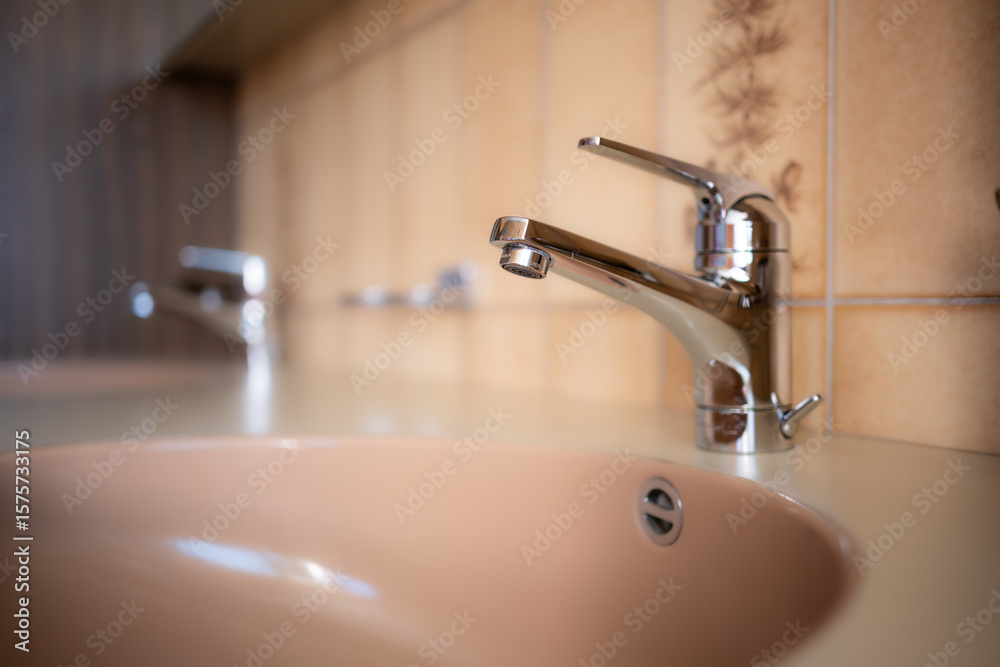 Shiny, chrome water tap inside apartment bathroom. Close up shot Shiny, chrome water tap inside apartment bathroom. Close up shot