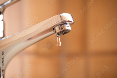 Tableau sur toile Dripping tap with water droplets inside apartment bathroom