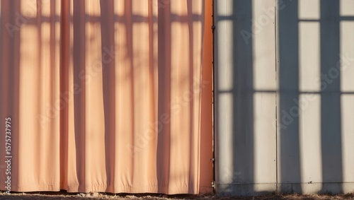 Wallpaper Mural Soft peach and gray curtains casting shadows in warm sunlight showcasing serene interior design Torontodigital.ca