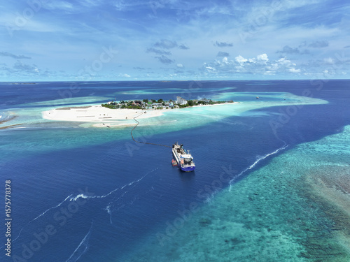 Aerial view of a vessel dredging sand from the ocean floor, Gulhi, Kaafu Atoll, Maldives.