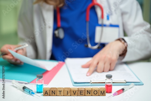 A healthcare professional is preparing antivenom for snake bite treatment in a clinical environment.