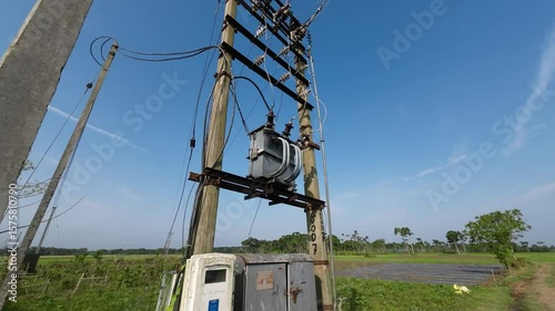 Electric Transformer and Power Lines in Rural Farmland Under Blue Sky