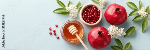 Fresh pomegranates and honey arranged beautifully for a healthy snack on a light background