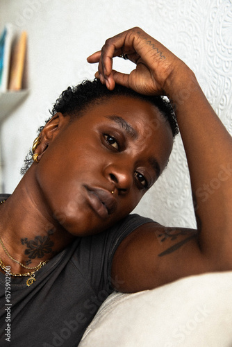 Portrait of a young Black queer woman looking into the camera.