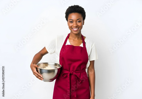 Smiling Black woman baker holds a mixing bowl, ready to bake.