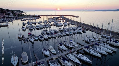 Boats parked in an Italian marina during a beatiful colorful sunset, drone shot UHD