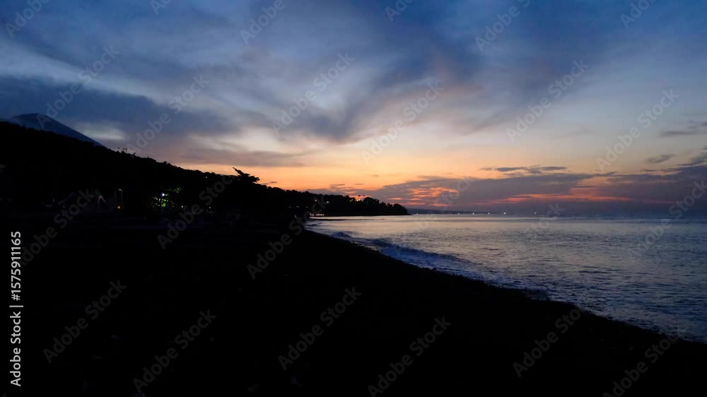 Balinese silhouetted coastal landscape and ocean with Mt Agung volcano during sunset in Amed on tropical island Bali Indonesia Balinese silhouetted coastal landscape and ocean with Mt Agung volcano during sunset in Amed on tropical island Bali Indonesia