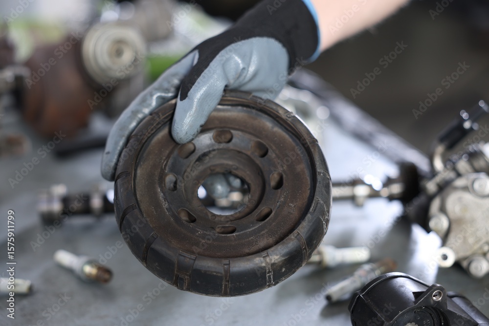 Auto part. Professional mechanic with strut mount at table indoors, closeup Auto part. Professional mechanic with strut mount at table indoors, closeup