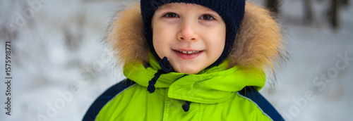 portrait of a little boy in a hat and jacket in winter