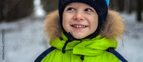 portrait of a little boy in a hat and jacket in winter