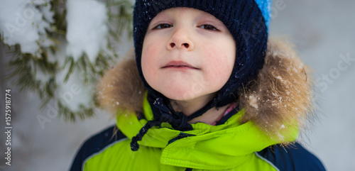 portrait of a little boy in a hat and jacket in winter