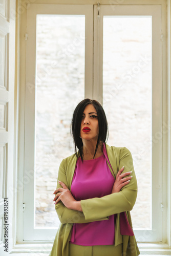 Free Download young woman in green coat posing in front of window - GFXLoad