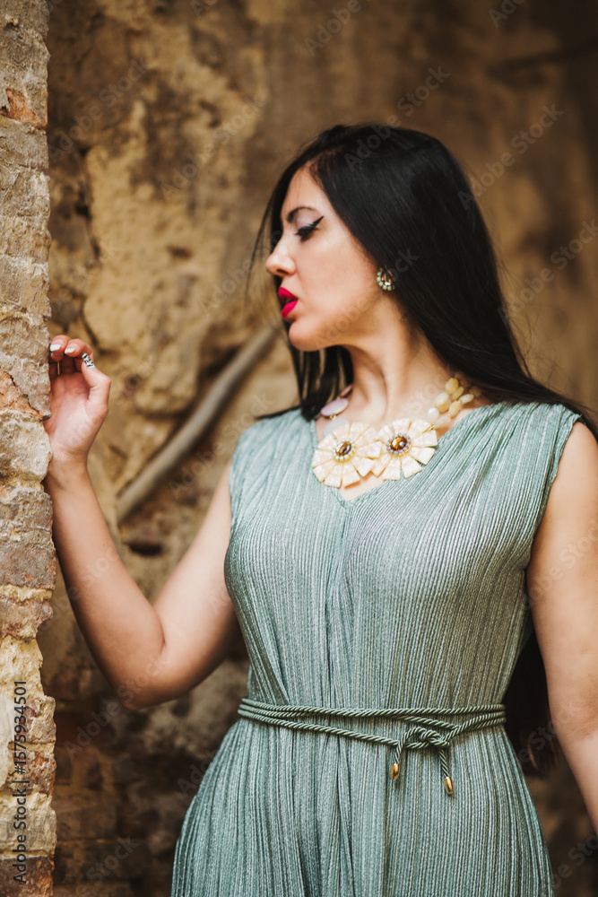Obraz premium portrait of young woman with red lips and black dress in front of old house