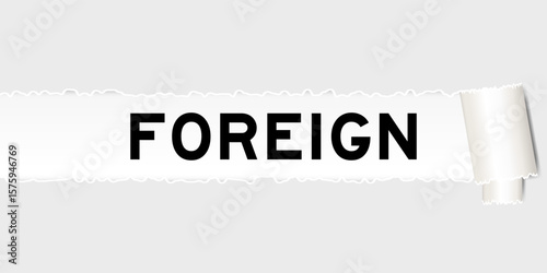Ripped gray paper background that have word foreign under torn part