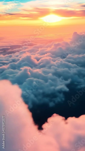 View above sea of fluffy clouds at golden sunset. Beautiful cloudy sky from plane window, colorful heaven background for meditation footage.