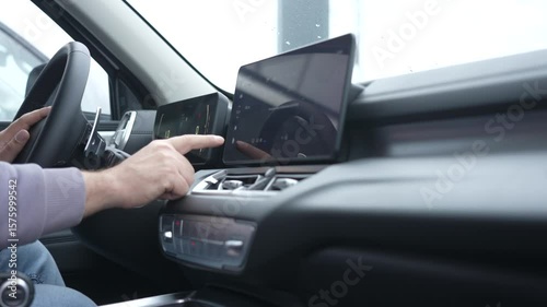 A man uses a touchscreen in a modern car. 