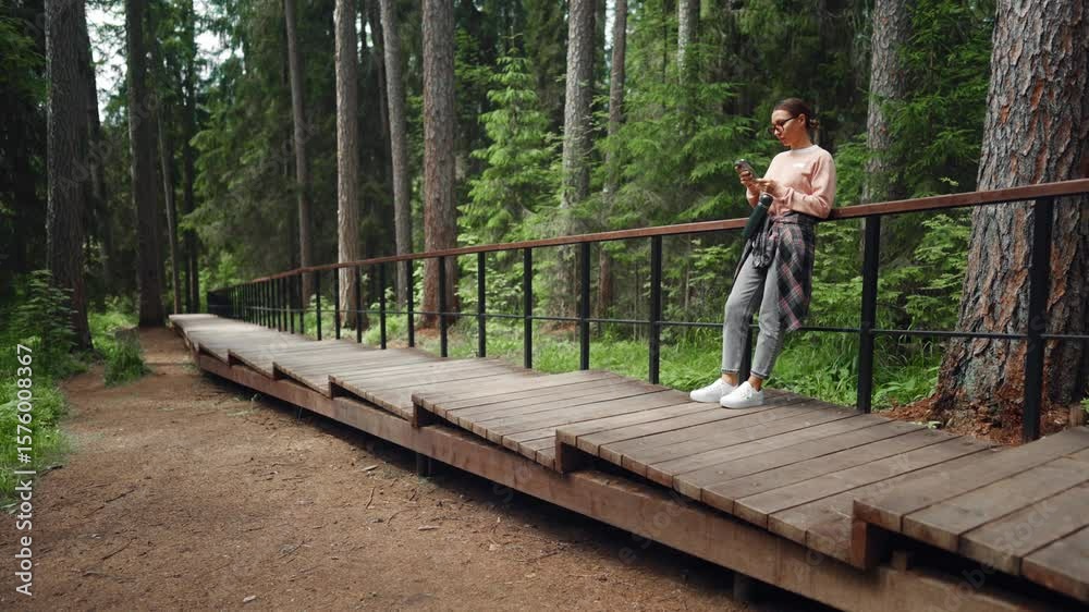 Carefree woman using mobile phone in forest, large mobile network coverage. Female traveler resting in nature in summer weekend, escape from city for recovery energy, internet addiction, mobile gadget Carefree woman using mobile phone in forest, large mobile network coverage. Female traveler resting in nature in summer weekend, escape from city for recovery energy, internet addiction, mobile gadget